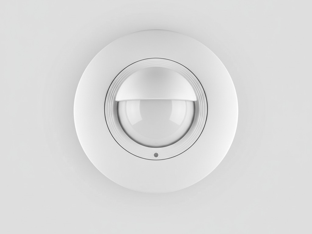 Uma foto limpa e simples de um sensor de ocupação branco, redondo, conectado à fiação, projetado para ser instalado no teto, mostrado contra um fundo simples.